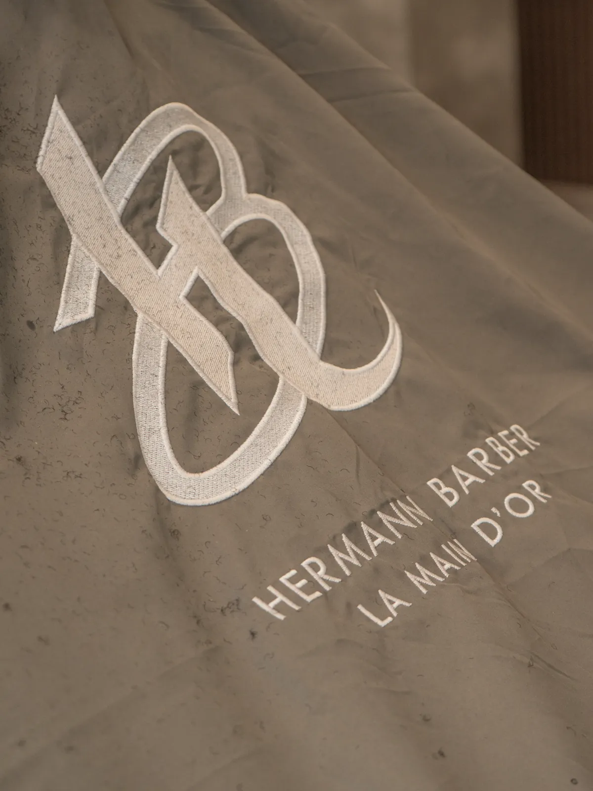A cape embroidered with the Hermann Barber monogram