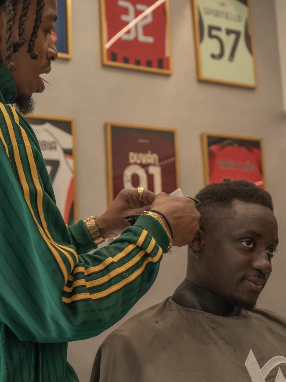 Hermann finishing a client’s nape in front of the wall of shirts
