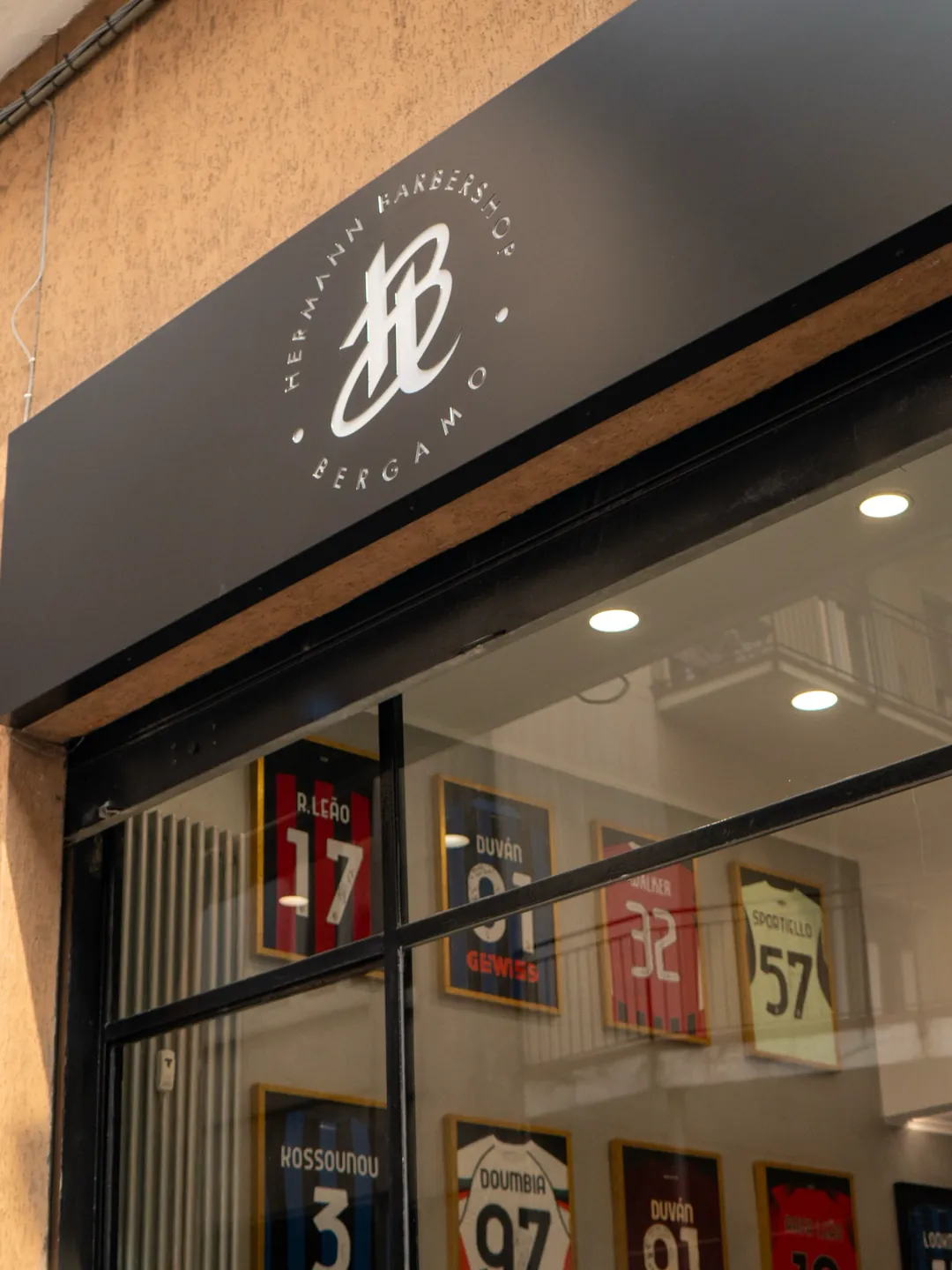 The Hermann Barbershop sign above the Via Casalino window