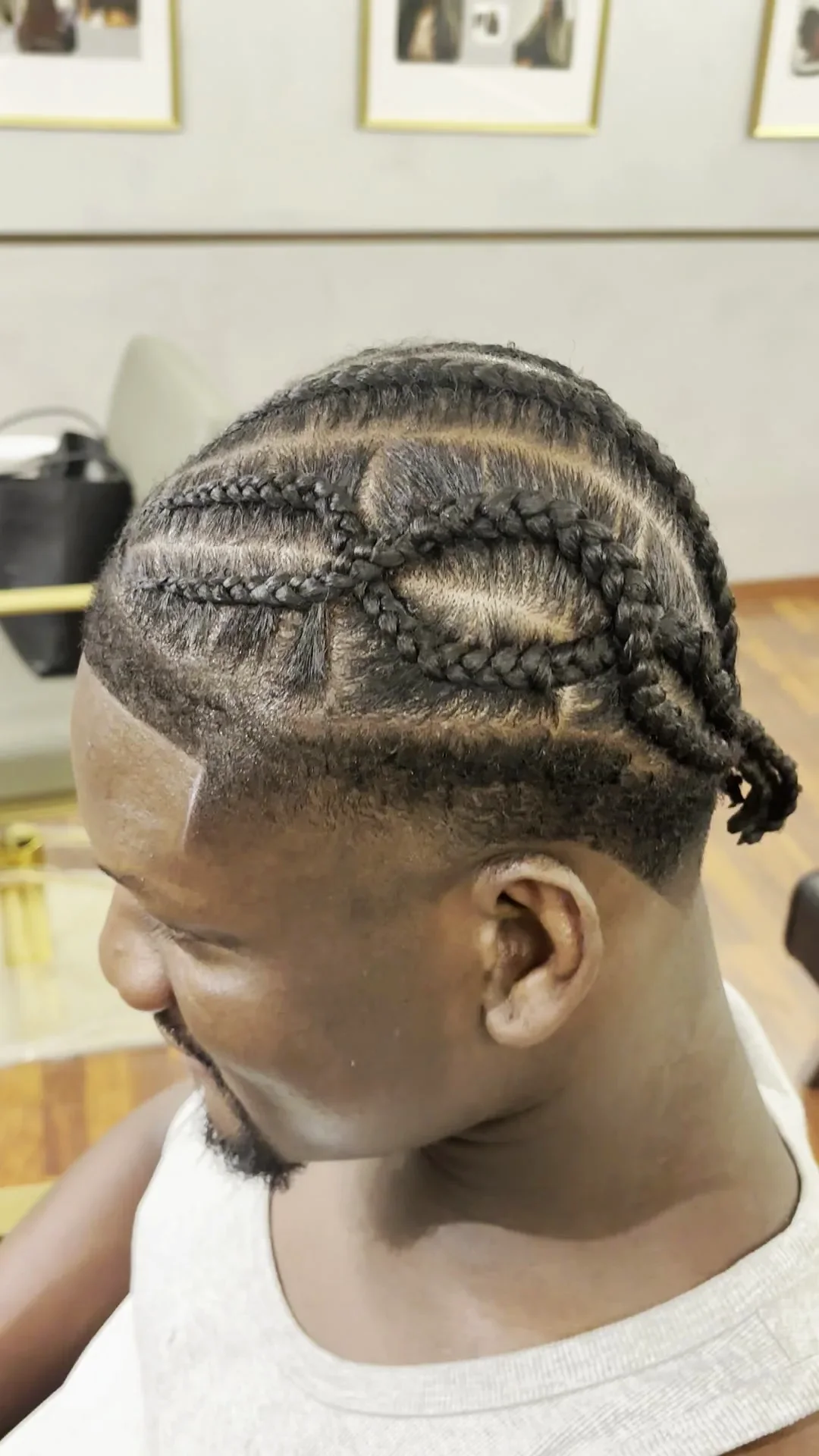 Cornrows with a drawn parting and a side fade