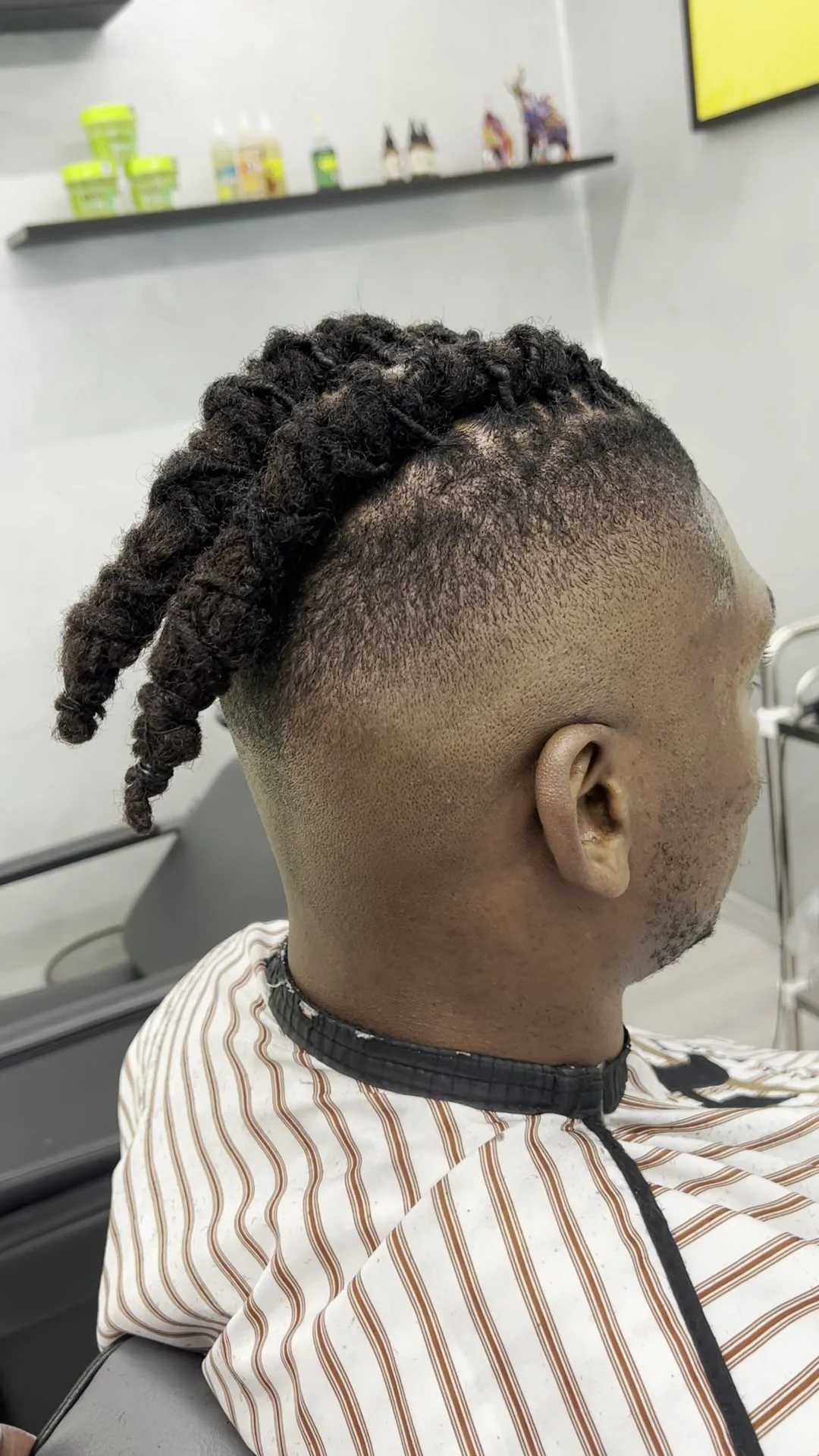 Locs tied up above a skin fade