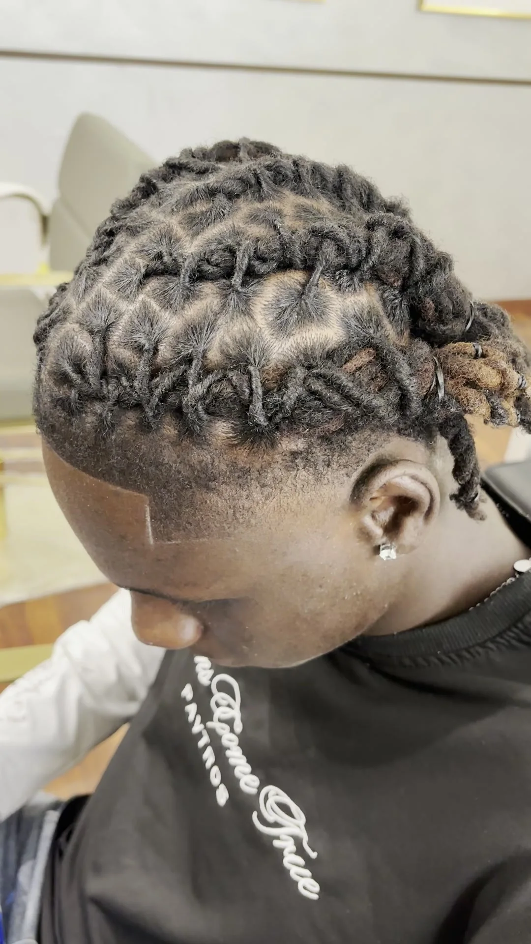 Dreadlocks twisted into a spiral, seen from behind